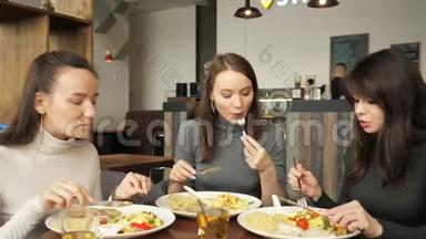 三个女朋友在咖啡馆里<strong>一起吃</strong>饭，聊天，享受他们的<strong>食物</strong>。